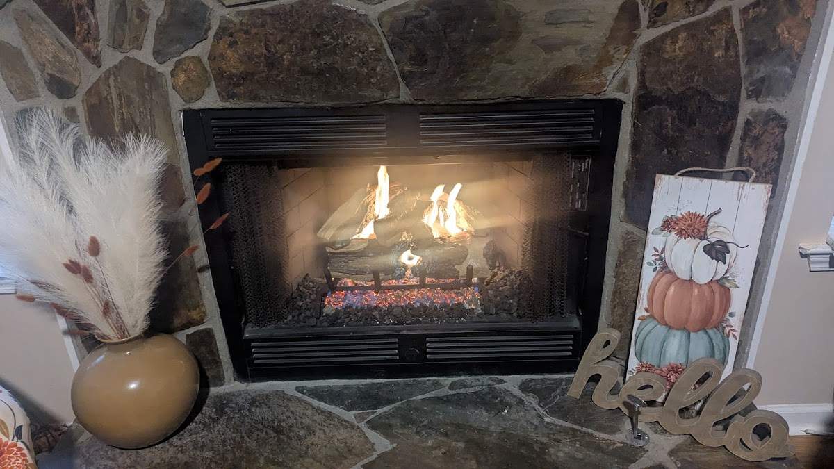 Stone fireplace with gas logs burning