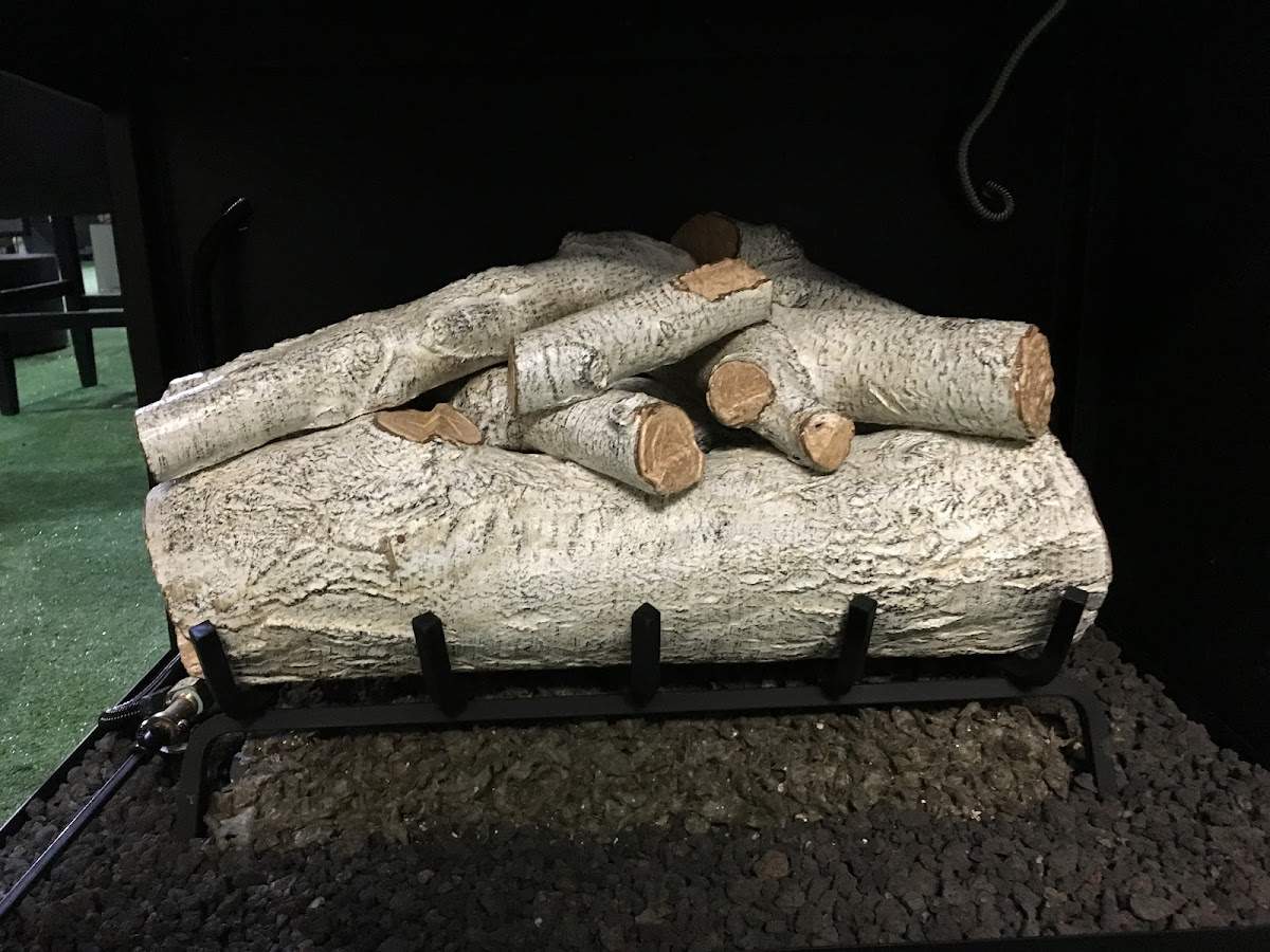Birch gas log set on black grate with lava rock
